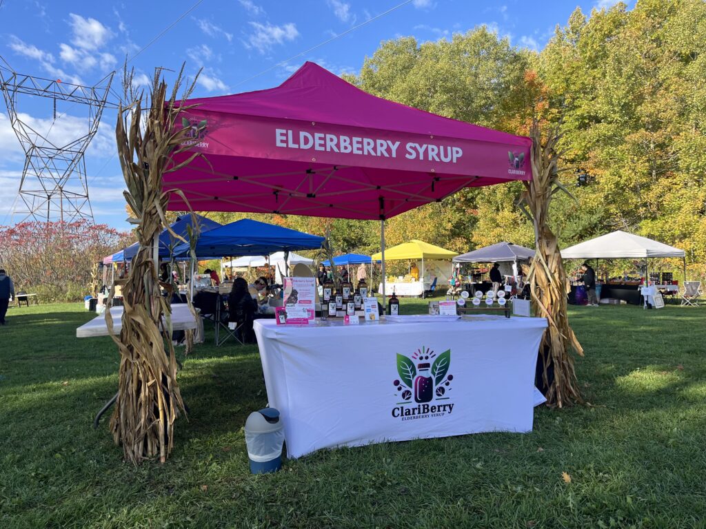 A market stand that says elderberry syrup on the banner.